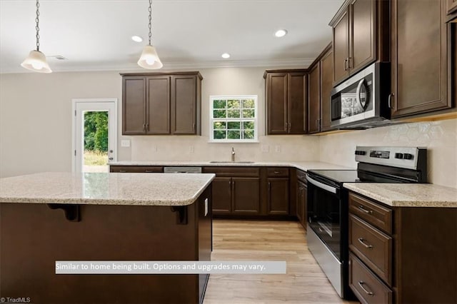 4099 Stallion St Lot 18, High Point, NC 27262 - kitchen featuring stainless steel appliances, a sink, light wood-type flooring, a breakfast bar area, and dark brown cabinets