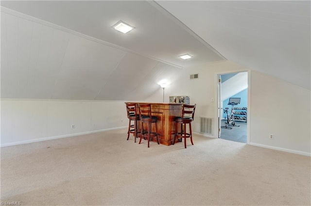 bonus room featuring lofted ceiling, light colored carpet, and indoor bar