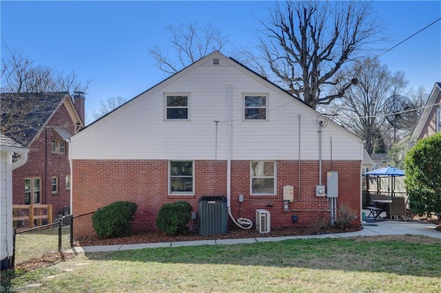 rear view of house featuring a yard, central AC, and a patio area