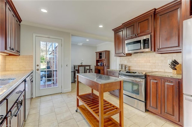 kitchen with tasteful backsplash, ornamental molding, light tile patterned floors, stainless steel appliances, and light stone countertops