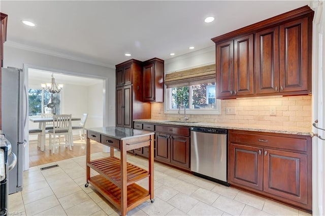 kitchen with light stone counters, stainless steel appliances, crown molding, and sink