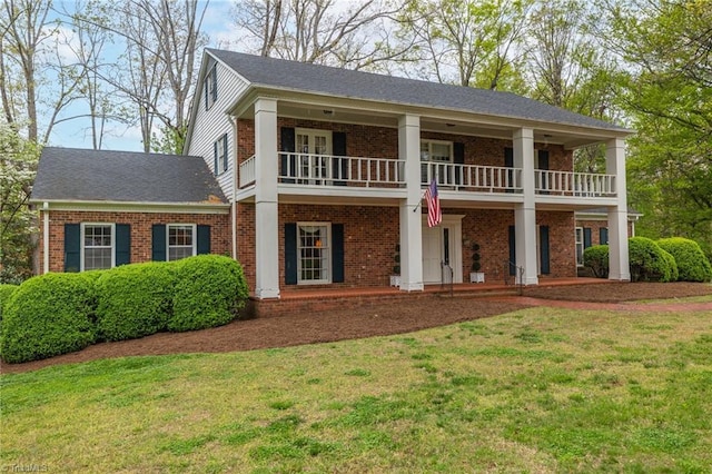 view of front of home featuring a front lawn and a balcony