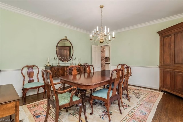 dining room with crown molding, a notable chandelier, and hardwood / wood-style flooring