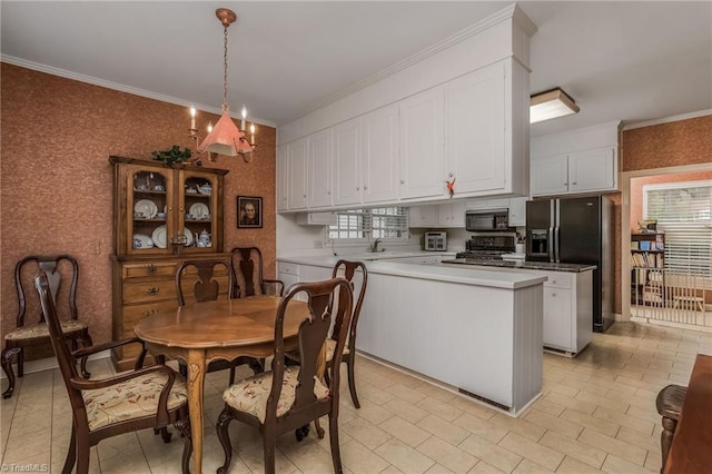 kitchen featuring hanging light fixtures, light tile floors, a chandelier, black appliances, and white cabinets