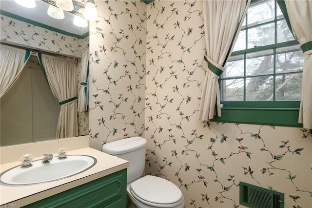 bathroom with toilet and vanity with extensive cabinet space