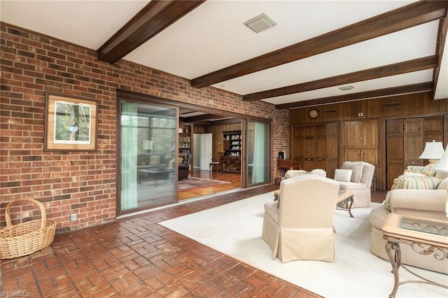 living room featuring wood walls, brick wall, and beam ceiling