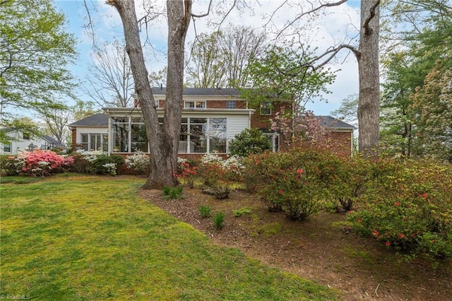 back of house with a lawn