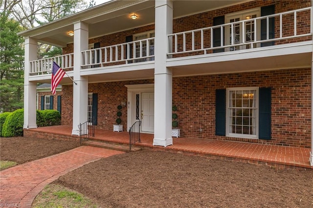 rear view of house with a balcony and a porch