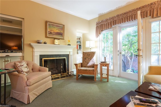 living area featuring carpet floors, ornamental molding, and a tile fireplace