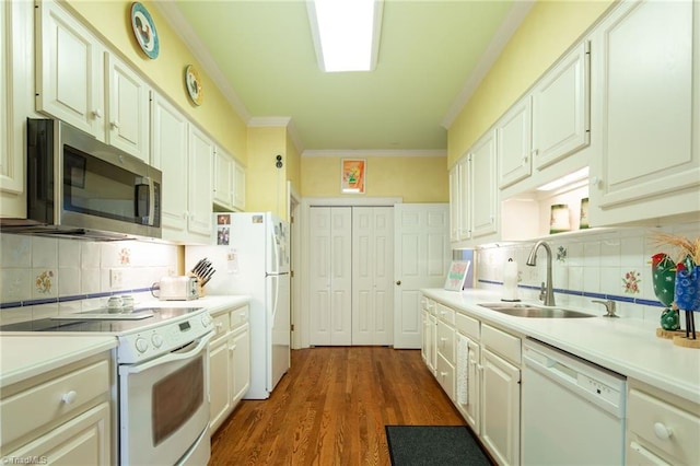 kitchen with white appliances, sink, dark hardwood / wood-style floors, ornamental molding, and white cabinetry