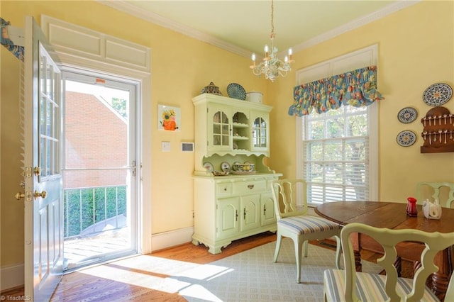 dining area with light hardwood / wood-style floors, crown molding, and a wealth of natural light