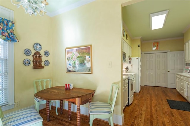 dining space with ornamental molding, a notable chandelier, and hardwood / wood-style flooring