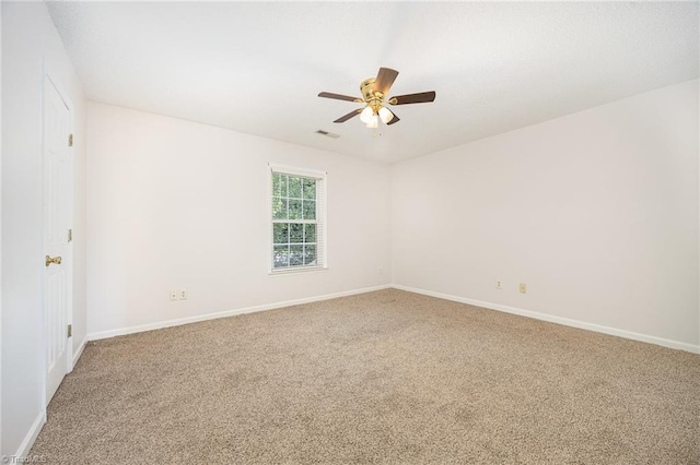 spare room featuring baseboards, ceiling fan, carpet flooring, and visible vents