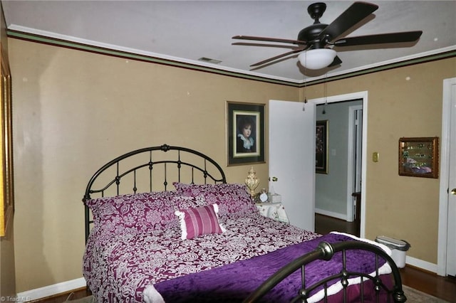 bedroom featuring ceiling fan, ornamental molding, and hardwood / wood-style floors