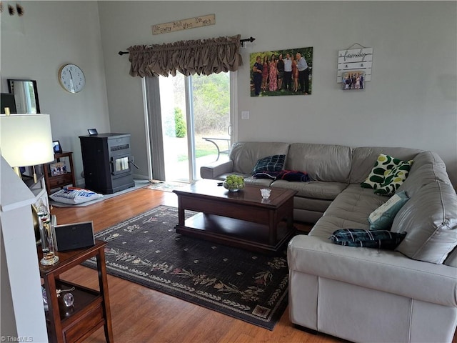 living room with a wood stove and light hardwood / wood-style flooring