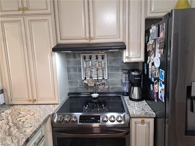 kitchen with stainless steel electric range oven, light stone counters, backsplash, cream cabinets, and black fridge