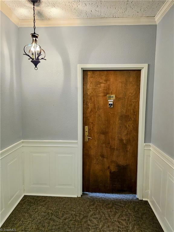 interior space featuring dark carpet and a textured ceiling