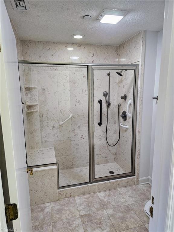 full bathroom with a shower stall, visible vents, and a textured ceiling