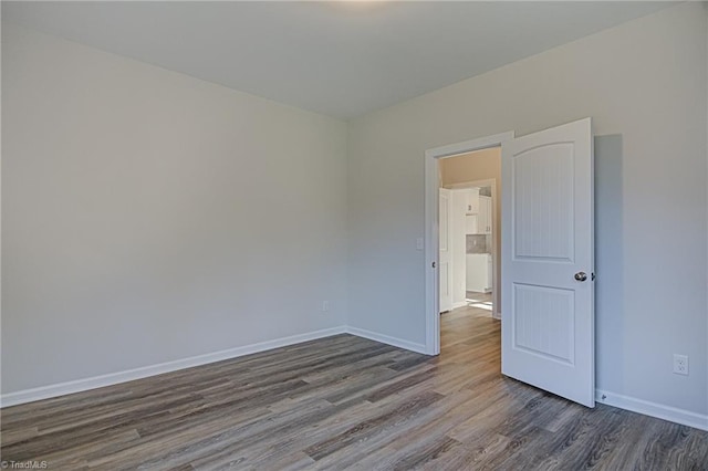 empty room with dark hardwood / wood-style flooring