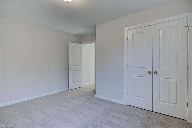 unfurnished bedroom with a closet and light carpet