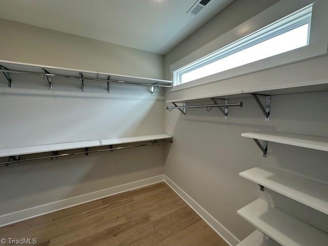 spacious closet with hardwood / wood-style flooring