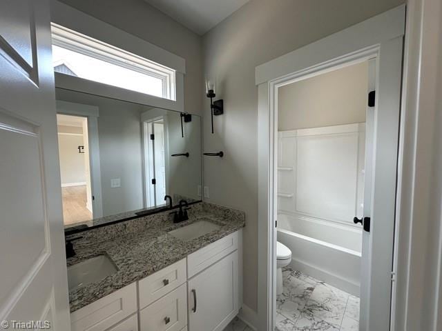 full bathroom featuring vanity, toilet, and washtub / shower combination