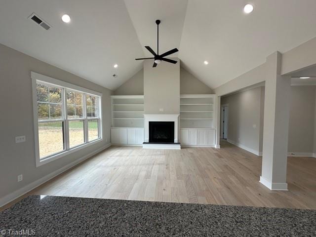 unfurnished living room featuring built in features, high vaulted ceiling, light hardwood / wood-style flooring, and ceiling fan