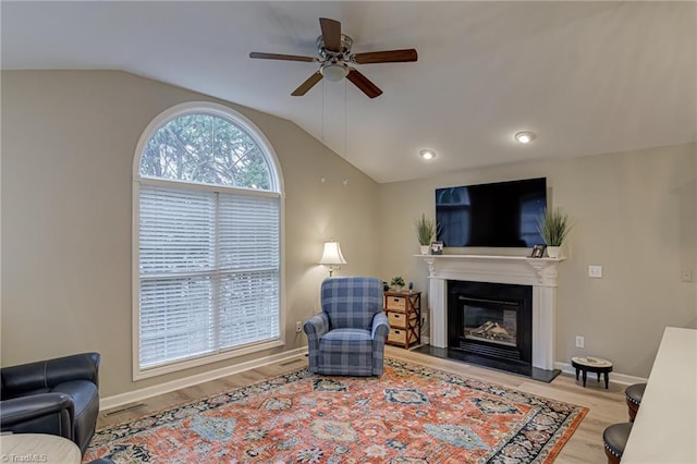 living room with ceiling fan, plenty of natural light, light hardwood / wood-style flooring, and lofted ceiling