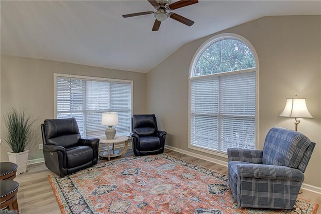 living area with vaulted ceiling, light hardwood / wood-style floors, and plenty of natural light