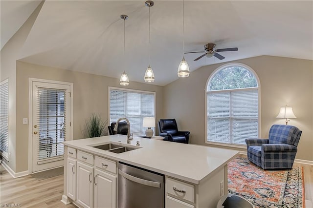 kitchen featuring white cabinetry, a kitchen island with sink, stainless steel dishwasher, sink, and vaulted ceiling