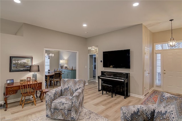 living room with a notable chandelier and light hardwood / wood-style flooring