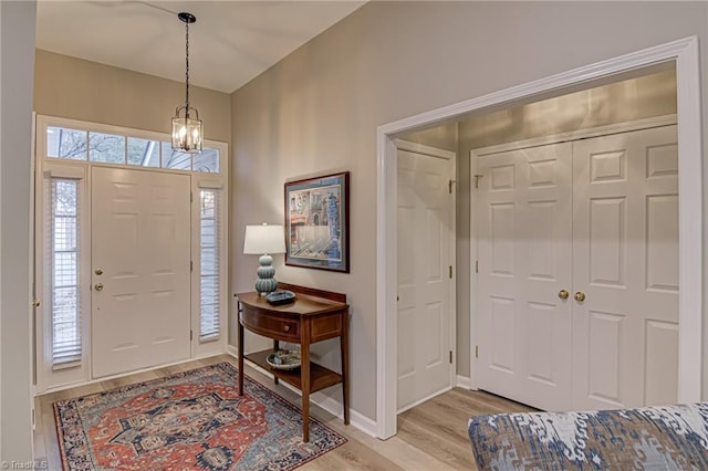 entrance foyer with light hardwood / wood-style flooring and a notable chandelier