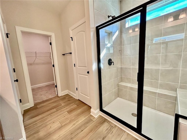 bathroom featuring a shower with shower door and hardwood / wood-style floors