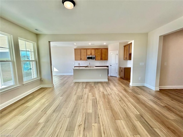 unfurnished living room with sink and light wood-type flooring