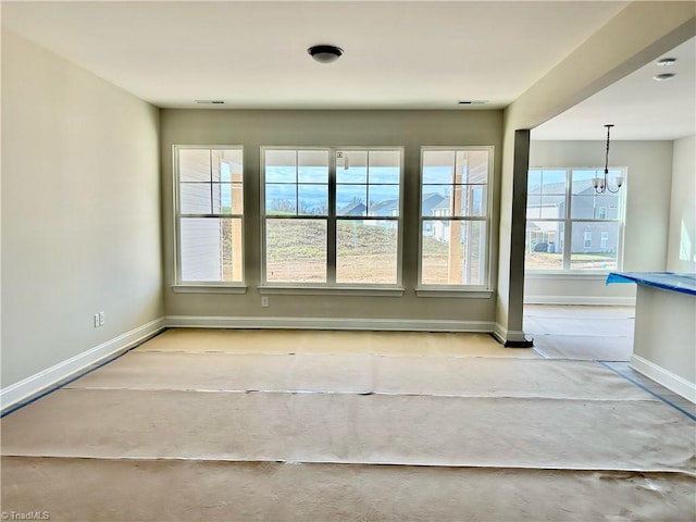 unfurnished room with a notable chandelier