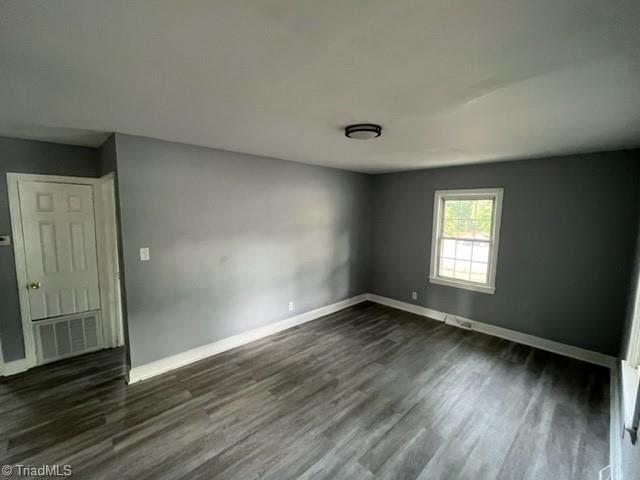 spare room featuring dark wood-type flooring