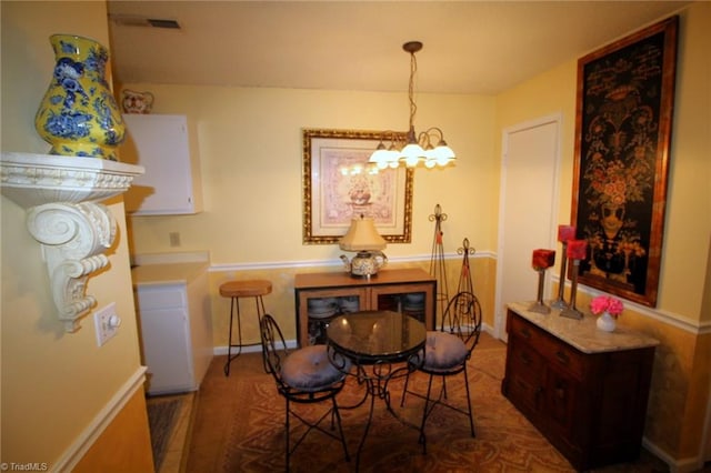 dining room featuring wood-type flooring and an inviting chandelier