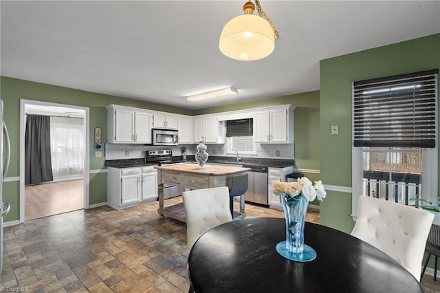 kitchen featuring decorative backsplash, white cabinets, and appliances with stainless steel finishes