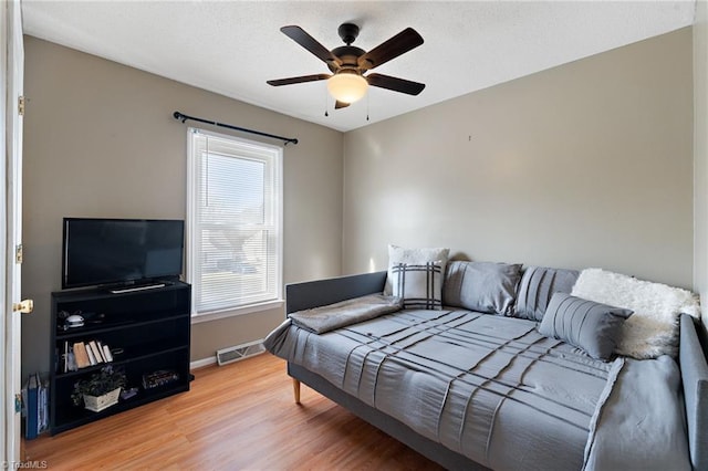 bedroom with visible vents, ceiling fan, baseboards, and wood finished floors