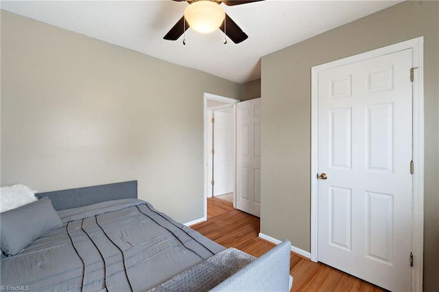 bedroom featuring light wood-style floors, baseboards, and ceiling fan