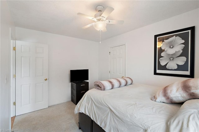 bedroom featuring light carpet and a ceiling fan