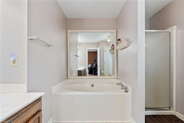 bathroom with vanity, a shower stall, a bath, and wood finished floors