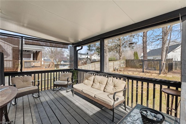 wooden deck featuring an outdoor living space and a fenced backyard