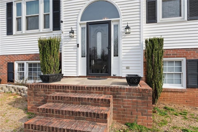 doorway to property featuring brick siding