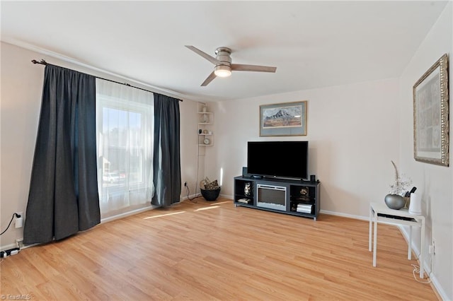 living room with light wood-type flooring, baseboards, and a ceiling fan