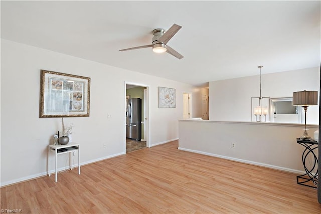 unfurnished living room with baseboards, light wood-style flooring, and a ceiling fan