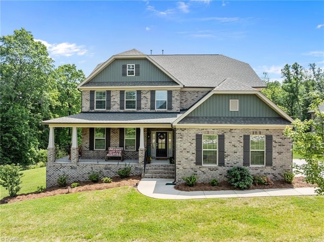 8018 Hacker Dr, Stokesdale, NC 27327 - craftsman-style home featuring a front lawn, a porch, brick siding, and roof with shingles