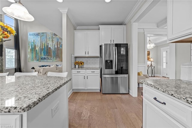 8018 Hacker Dr, Stokesdale, NC 27327 - kitchen with stainless steel fridge with ice dispenser, ornamental molding, light wood-type flooring, white cabinetry, and light stone countertops