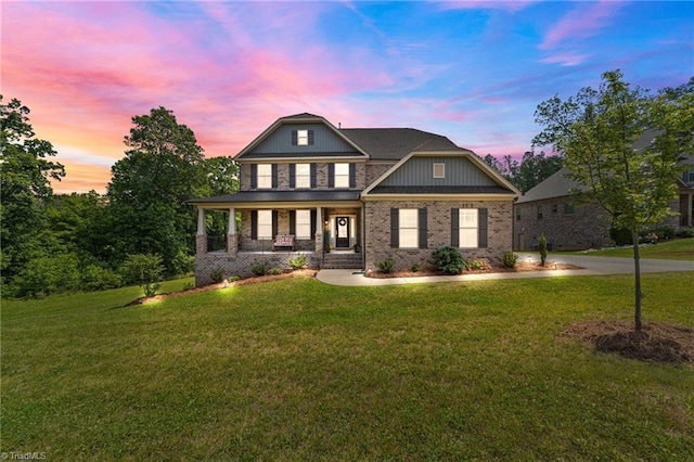 8018 Hacker Dr, Stokesdale, NC 27327 - view of front of house with a porch, a front yard, and brick siding