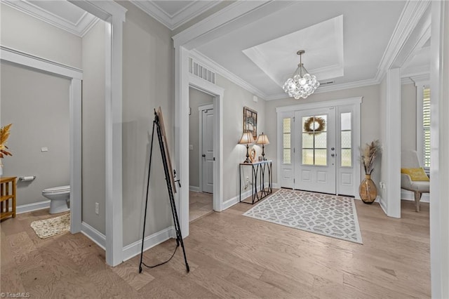 8018 Hacker Dr, Stokesdale, NC 27327 - foyer entrance featuring light wood-style floors, a chandelier, ornamental molding, baseboards, and a tray ceiling
